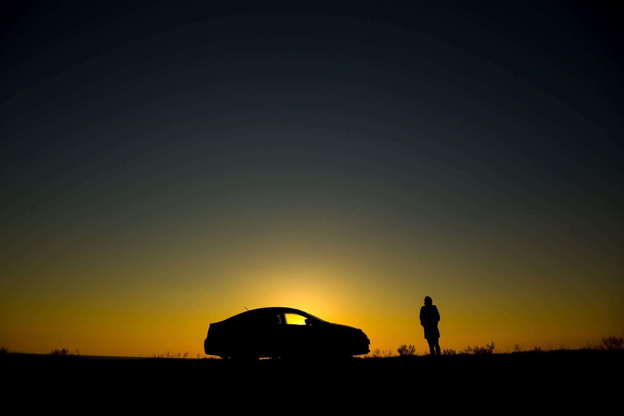 Silhouette of sedan car on the background of beautiful sunset